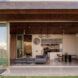 Open sliding glass doors look into a living room area from the yard.
