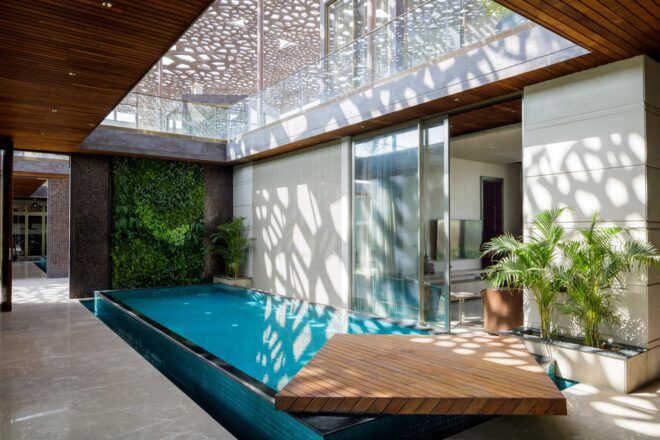 A dappled roof sends a pattern of light and shadow over a covered pool area.