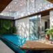 A dappled roof sends a pattern of light and shadow over a covered pool area.