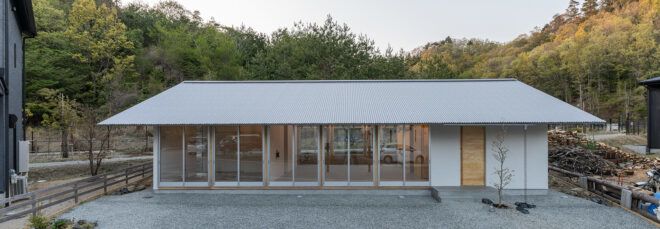 one-story metal home with slanted roof and wood front door