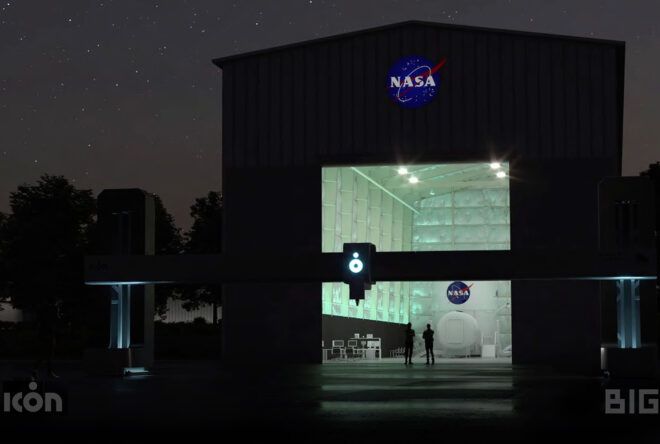 A dark landscape lit up only by a NASA building with a NASA sign on top and a large open factory door looking inside.