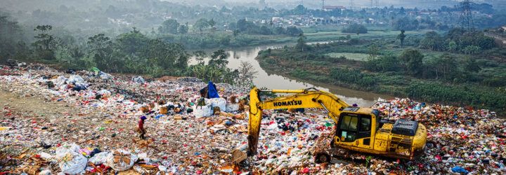 A landfill with a tractor moving garbage.