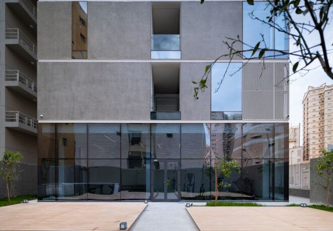 The back of the building, showing the metal facade and a bottom level with glass walls.