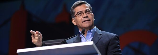 Xavier Becerra standing in front of a podium.