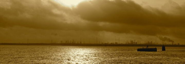 A cloudy, polluted bay area with an ExxonMobil facility in the distance.