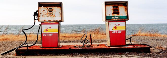 Two old-fashioned, rusted gas pumps.