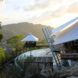 large home surrounded by smaller homes all with white tensile roofs