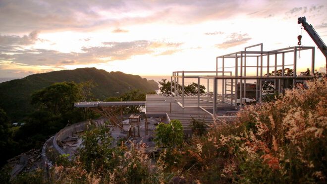 steel house frame on an island at sunset