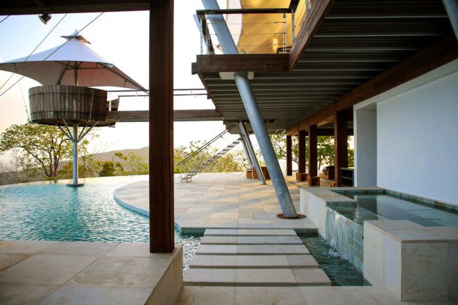 concrete path to patio surrounded by a pool