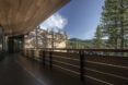 A deck with a wooden roof overhang. The deck looks out on a forested mountain.