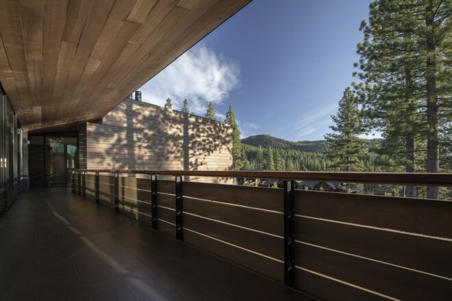 A deck with a wooden roof overhang. The deck looks out on a forested mountain.