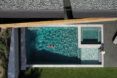 An overhead view of a person swimming in a rectangular pool.