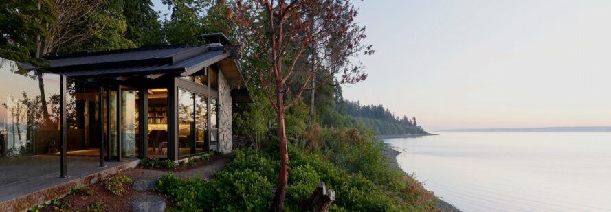 To the left, a single-level home looks out on the Puget Sound to the right.
