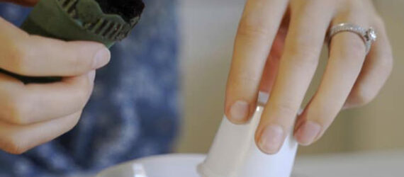 A pair of hands separating the pieces of a coffee pod.