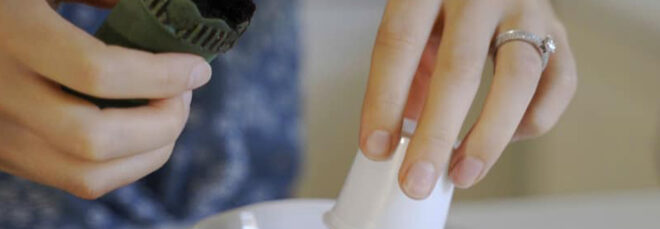 A pair of hands separating the pieces of a coffee pod.