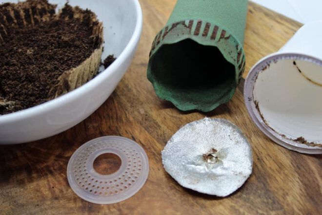 A green cone-like device next to a deconstructed coffee pod.