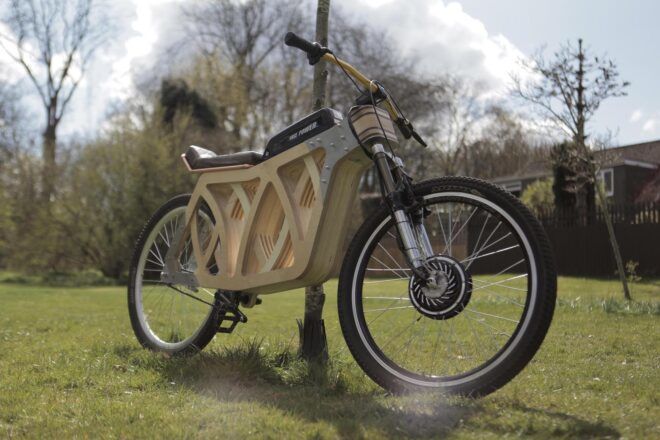 A wooden e-bike on a grassy lawn.