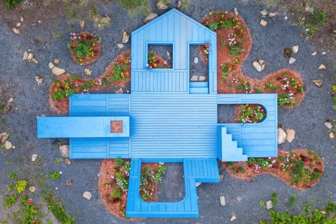 An overhead view of a blue house opened up to look like an exploded diagram of a house.