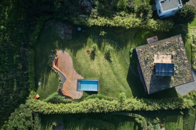 A bird's-eye view of the home and it's backyard, showing a pool, walkway and rooftop garden.