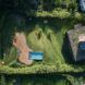A bird's-eye view of the home and it's backyard, showing a pool, walkway and rooftop garden.