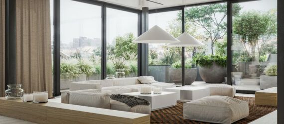A living room with a white sofa, coffee table and ottoman, surrounded by floor-to-ceiling windows.
