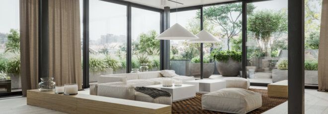 A living room with a white sofa, coffee table and ottoman, surrounded by floor-to-ceiling windows.