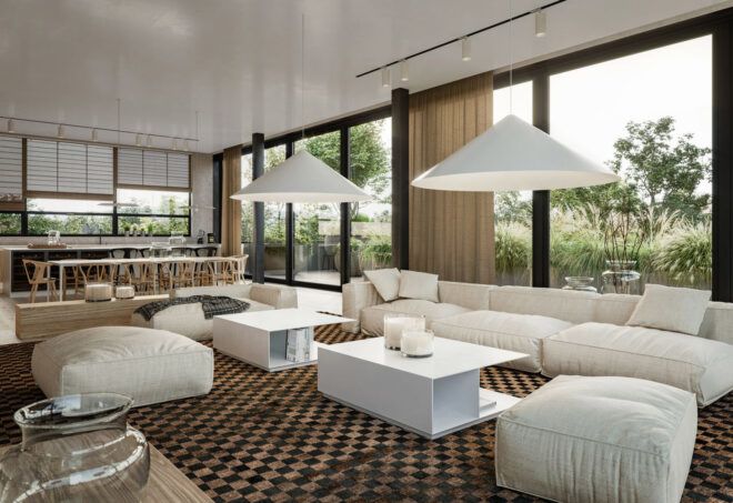 A living room with a white sofa, coffee table and ottoman, surrounded by floor-to-ceiling windows. In the background is a kitchen with a table and chairs.