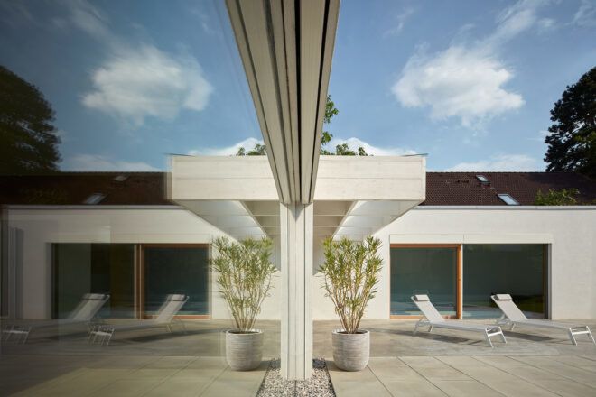 The outdoor patio mirrored against a glass wall on the home's exterior.