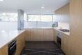 A kitchen with white walls and light-toned wood cabinets.