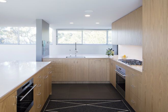 A kitchen with white walls and light-toned wood cabinets.