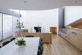 A view of the dining area, where a white table surrounded by black chairs overlooks the living room.