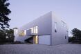 A boxy structure with a white facade and several windows.