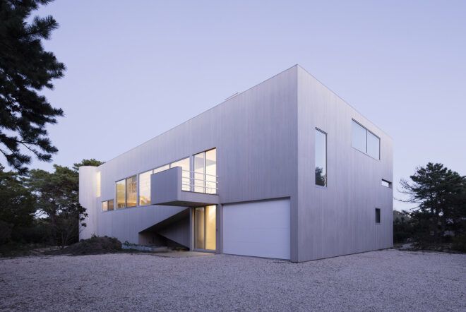 A boxy structure with a white facade and several windows.