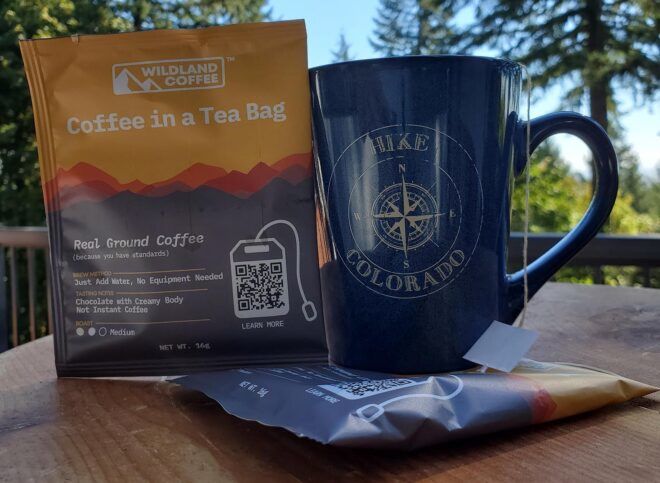 A blue mug to the right of an orange and gray packet of coffee.