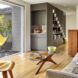 An open living room with wood floors connects to an outdoor deck.