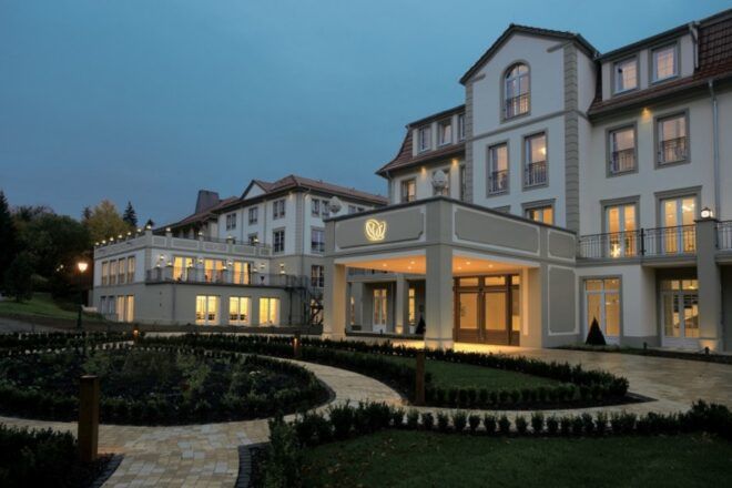 A driveway up to a hotel lit up at night.