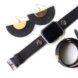 A pair of black semi-circle earrings, a black watch and a black bracelet against a white background.