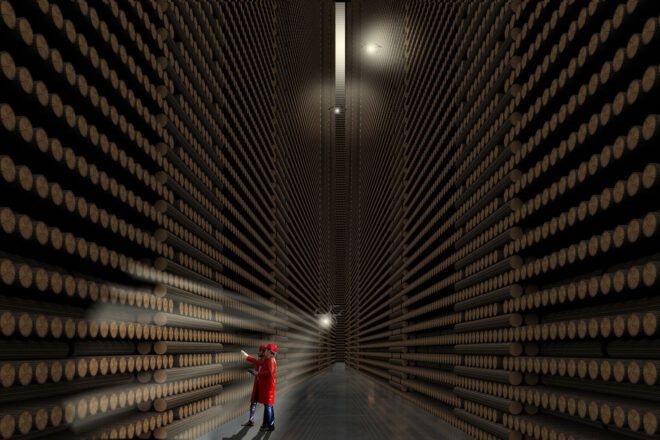 A person in red inspecting rows of logs.