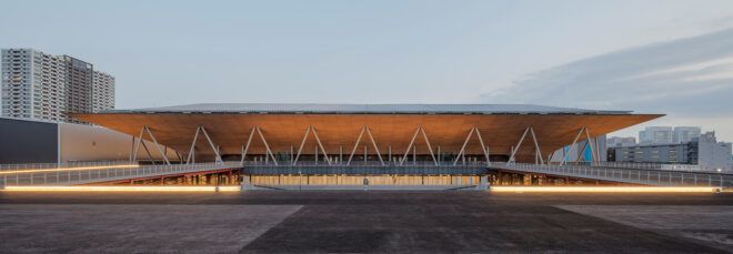 A landscape view of a squat building with a large overhanging roof.
