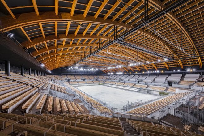 A view of a sports court from the top of an arena of wood bleachers.