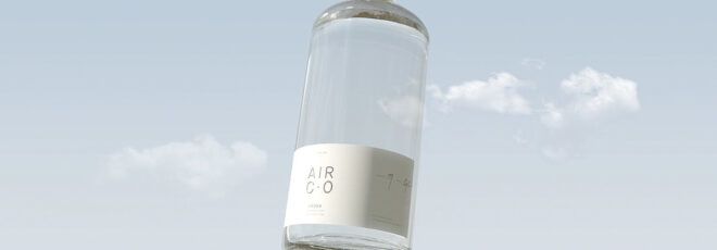 A clear bottle with a white lable against a blue sky background.