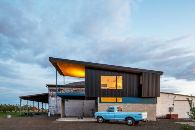 A two-story home with an assymetrical black roof.