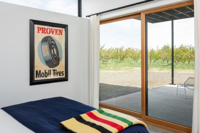 A bedroom with white walls and a blue bed.