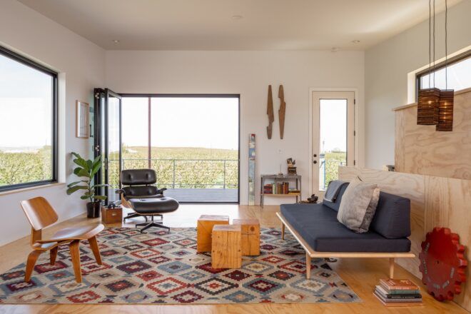 A living room with blue sofa and patterned rug.