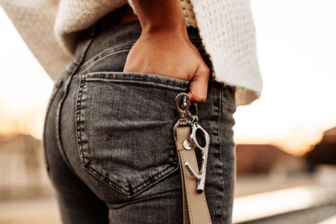 A leather keychain attached to the back of a person's jeans.