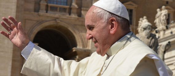 Pope Francis with his arm raised.