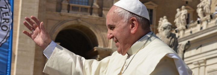 Pope Francis with his arm raised.