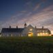 A landscape shot of the white building at dusk.