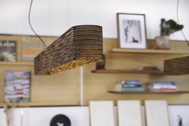 A wicker lighting fixture hanging from the ceiling in a room.