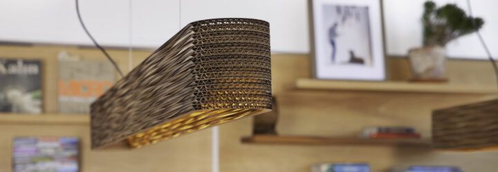 A wicker lighting fixture hanging from the ceiling in a room.